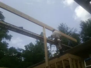 Carpenter setting a ridge beam over a new addition frame — Ice Dam Removal by Roofing Brothers in Lyme
