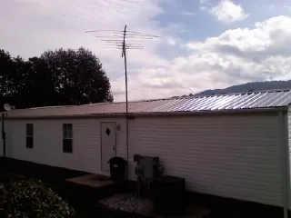 New metal roof on a single wide mobile home with a TV antenna in Lyme