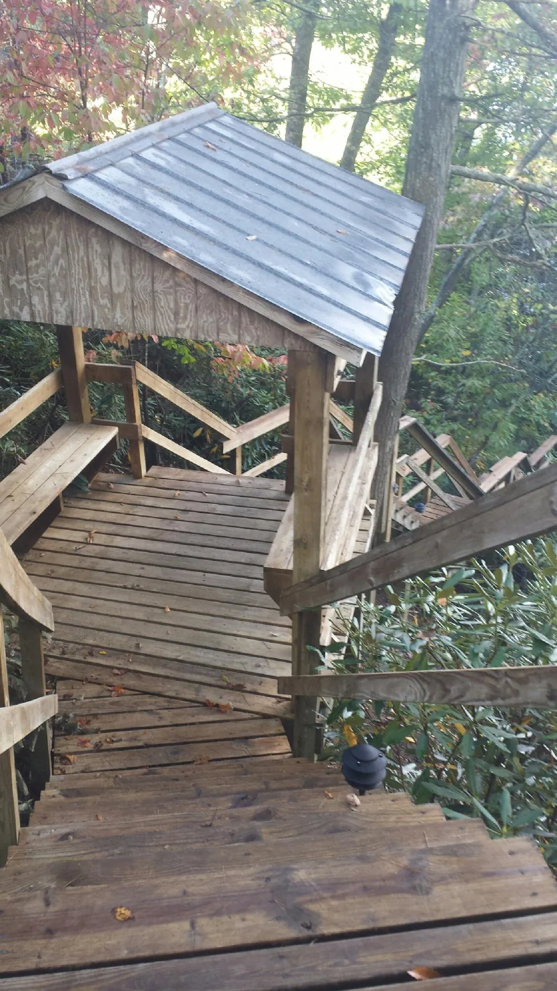 Metal roofed shelter over wooden steps on a wooded walkway — Skylight Repair & Installation work by our crew in Lyme