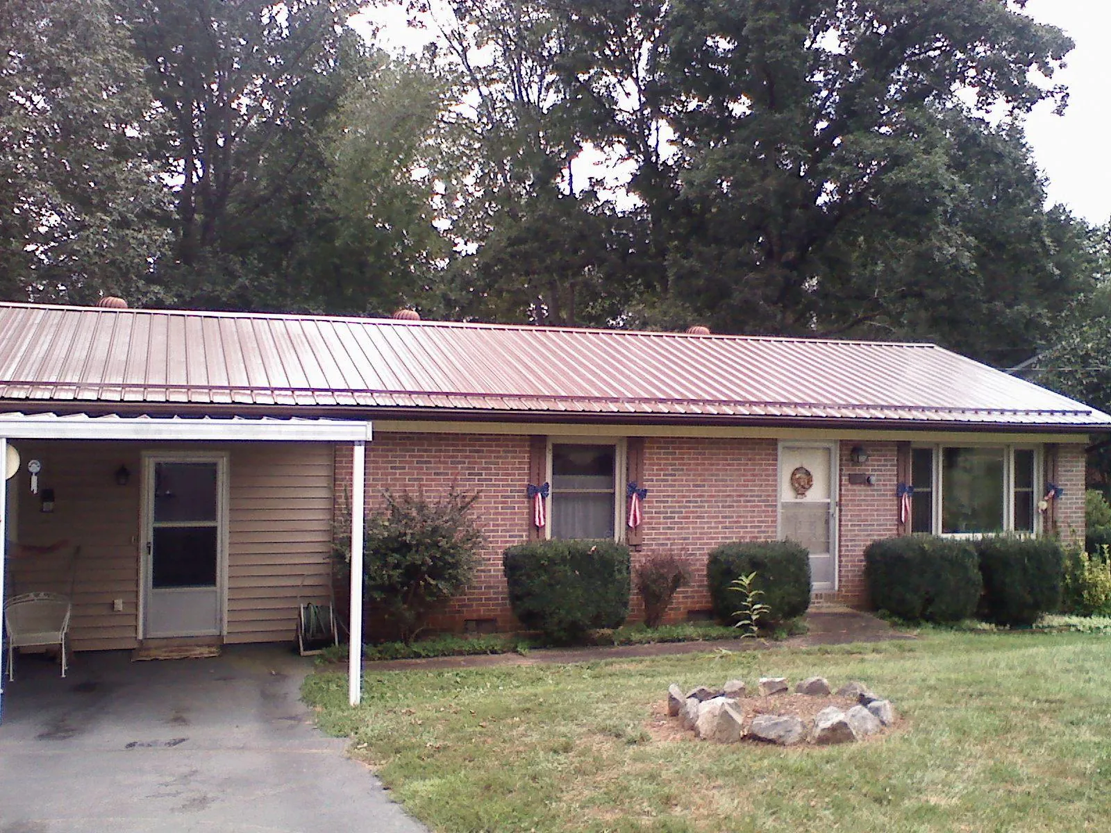 Bronze metal roof and carport on a brick ranch home — Roof Repair work by our crew in Lyme